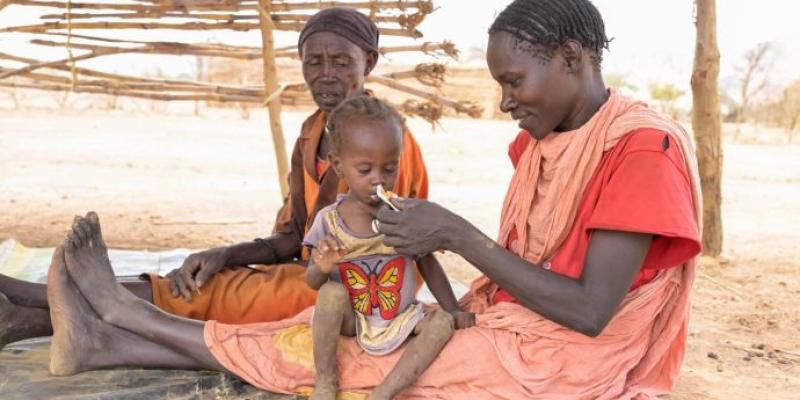 This mother received a special nutrient-packed paste for her malnourished child. Twenty-three children have died in the camps over the past month.