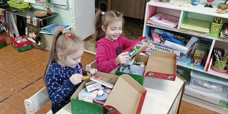 Two girls exploring their shoebox gifts