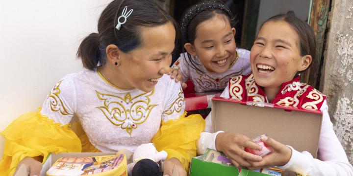 girls smiling as they explore their shoebox