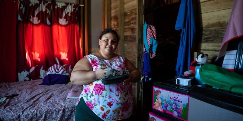 Yohemy Peña proudly displays a pair of shoes that one of her children received in their shoebox gift. 