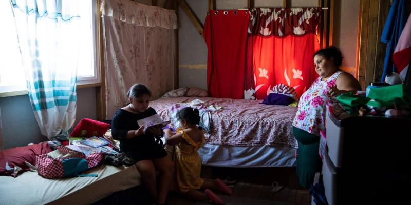 Some of the Peña children enjoy going through the items in their Operation Christmas Child shoebox gifts while Yohemy watches with gratitude. 