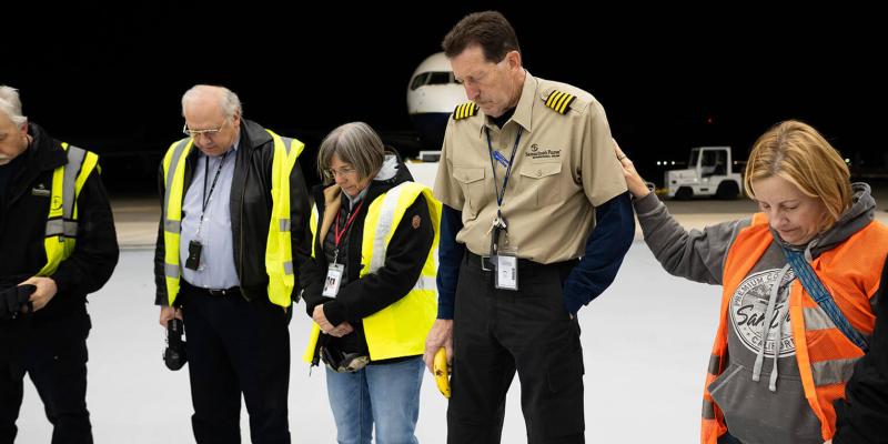 Samaritan's Purse staff gather to pray before the flight.