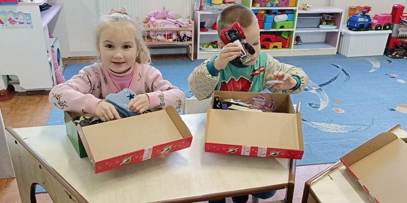 children opening shoebox gifts at school