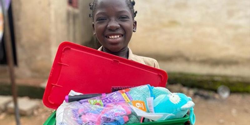 girl holding plastic shoebox