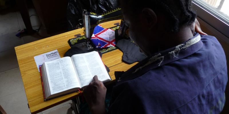 GARMAI READS FROM THE GOSPELS DURING A BREAK IN HER SEWING CLASS.