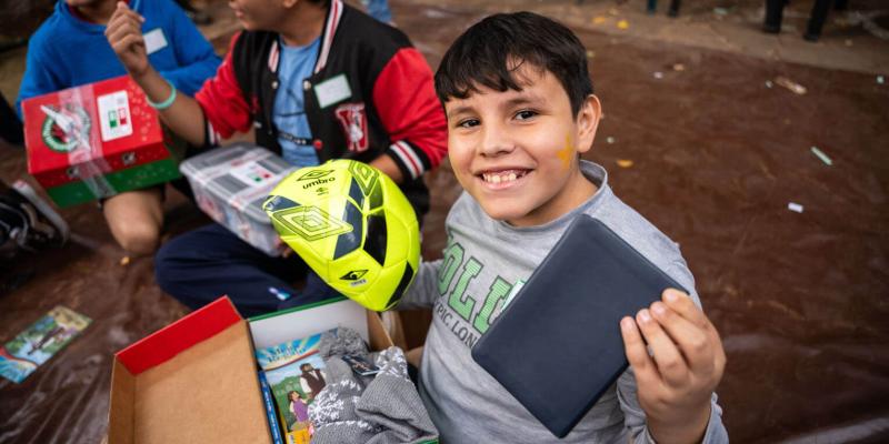 Rafael shows off his new soccer ball and Spanish Bible.