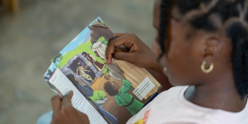 A child on Carriacou goes through The Greatest Gift Gospel booklet she received with her Operation Christmas Child shoebox gift. 