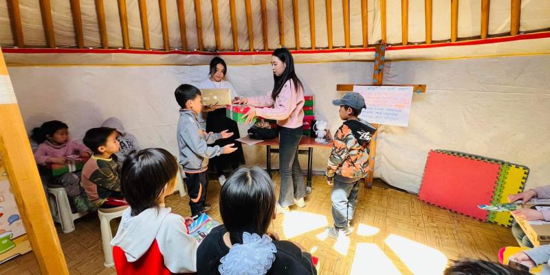 A local church partner leads the distribution of gifts for these boys and girls.