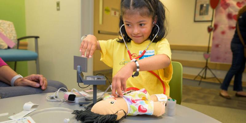 At Sutter Health, Dara listens for the heartbeat of a doll.