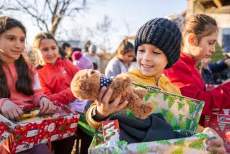 A young boy in Romania enjoys playing with his new teddy.