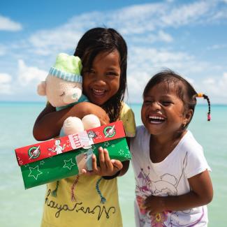 Two girls smiling with cuddly toy