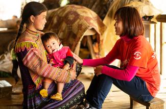 lady teaching girl with baby