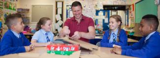 Group of school children assembling preprinted shoeboxes