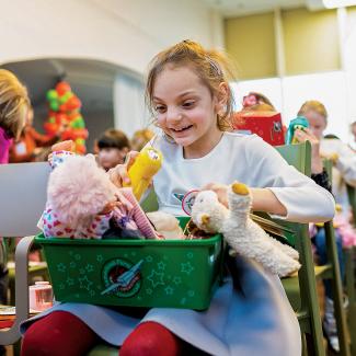 Girl with shoebox full of toys