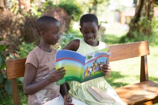 Two girls reading the Greatest Journey book together