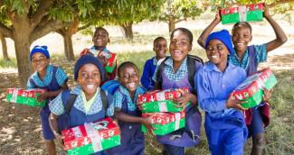 Children smiling with their OCC shoebox in hand