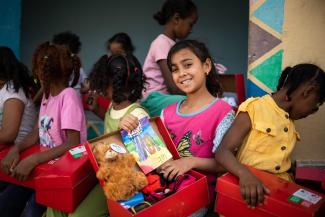 girl smiles with shoebox