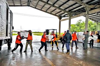 Teams load trucks destined for flood-devastated communities.