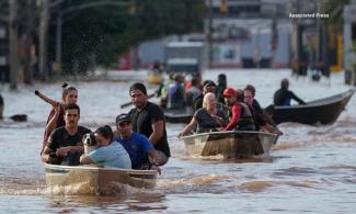 RESIDENTS ESCAPE BY BOAT FROM FLOODED COMMUNITIES IN SOUTHERN BRAZIL.