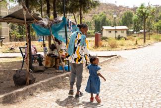 SAMRAWIT WALKS WITH HER YOUNGEST CHILD.