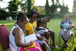 KHLOE AND OTHER CAMPERS STUDY THE SCRIPTURES DURING A BIBLE CLASS.