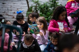 A little girl diligently reads The Greatest Gift booklet that explains the Gospel clearly for children to understand.