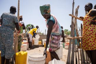 People gratefully gather to get their water.