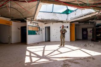 A soldier with the Israeli Defence Forces stands in a damaged community centre in the north.