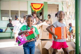 Girls leave the Operation Christmas Child outreach event at Hillsborough Primary School with their newfound treasures.