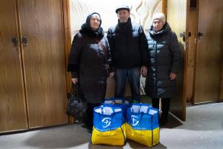 Oksana (left), Andrii, and their neighbor pray every day, believing that God will save them. The food they receive from Samaritan’s Purse reminds them of His constant presence.