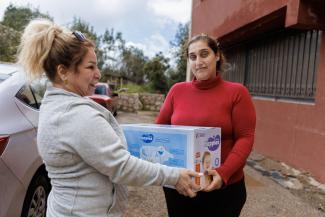 Ruz receives a box of supplies from a church partner in Lebanon.