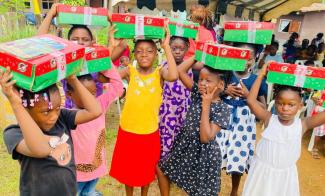 Girls in Gabon show off the shoebox gifts they received at an Operation Christmas Child outreach event.
