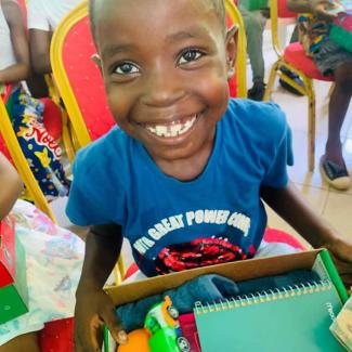 A boy at the Owendo outreach event can’t seem to smile big enough to express his joy over his shoebox gift.