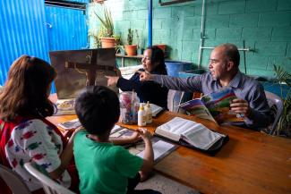 Marta’s pastor and his wife teach Angelita and her brother, Giovany, how to follow God through lessons of The Greatest Journey discipleship course.
