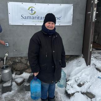 Kateryna clutches a new jug of water, grateful for how God is quenching both her physical and spiritual thirst.
